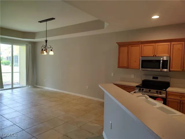 a kitchen with granite countertop a sink a counter top space cabinets and stainless steel appliances