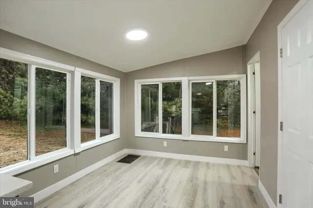 a view of an empty room with a floor to ceiling window and an entryway