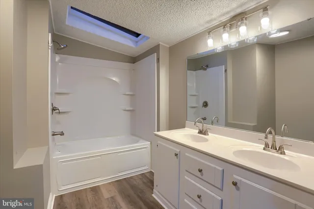 a bathroom with a tub a sink and mirror
