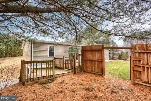 a backyard of a house with barbeque oven and wooden fence