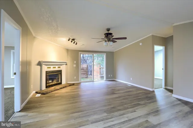 a view of an empty room with a fireplace and a window