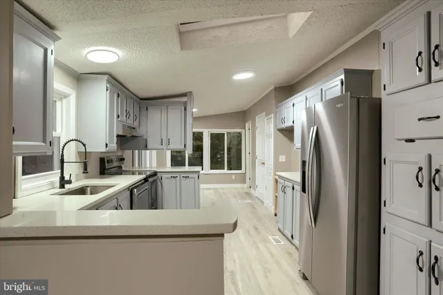 a kitchen with stainless steel appliances granite countertop a refrigerator and a sink