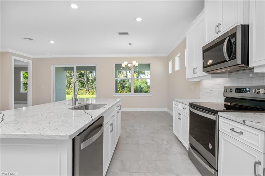 331 Tamarindo Lane Naples, FL 34114 - Photo 12 of 24 a kitchen with a stove and a microwave