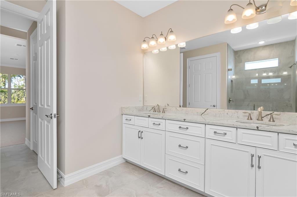 331 Tamarindo Lane Naples, FL 34114 - Photo 16 of 24 a bathroom with a double vanity sink and a mirror