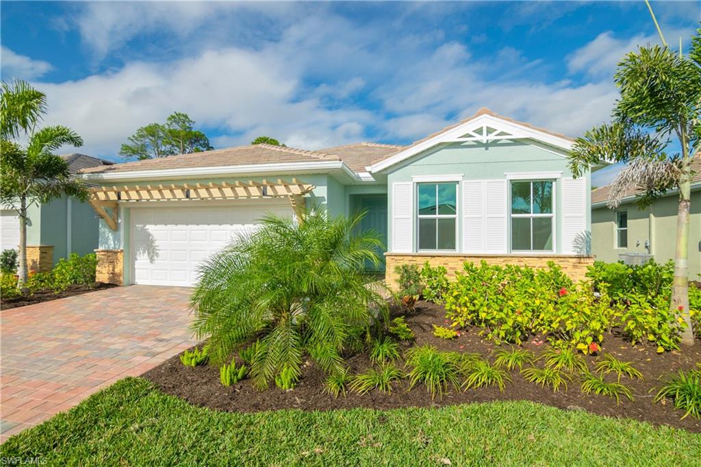 331 Tamarindo Lane Naples, FL 34114 - Photo 2 of 24 a front view of a house with garden