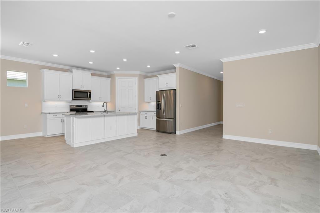 331 Tamarindo Lane Naples, FL 34114 - Photo 5 of 24 a view of kitchen with refrigerator and white cabinets
