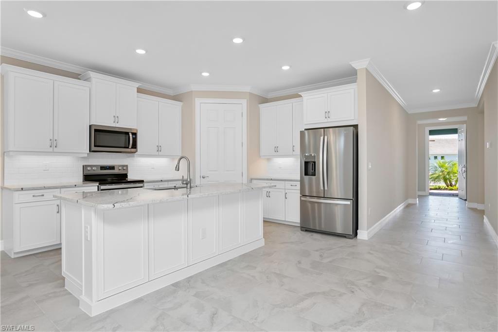 331 Tamarindo Lane Naples, FL 34114 - Photo 8 of 24 a kitchen with stainless steel appliances granite countertop a refrigerator a stove a microwave oven a sink with granite countertops and cabinets