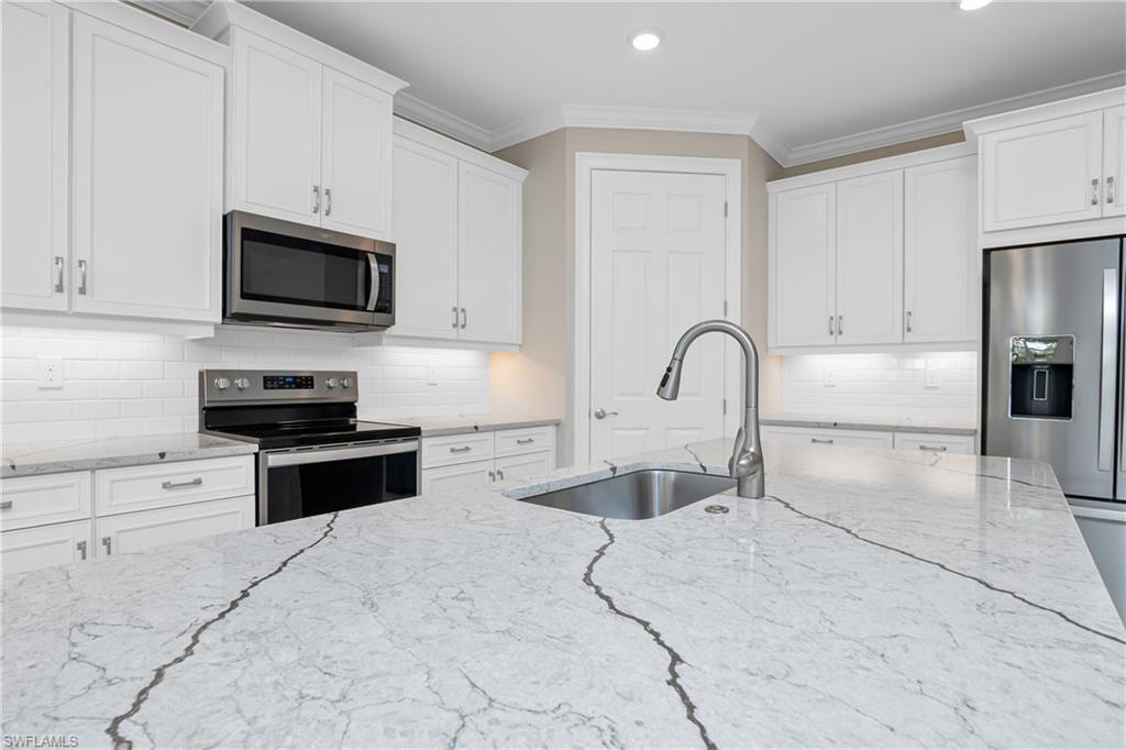 331 Tamarindo Lane Naples, FL 34114 - Photo 9 of 24 a kitchen with granite countertop a stove and a sink