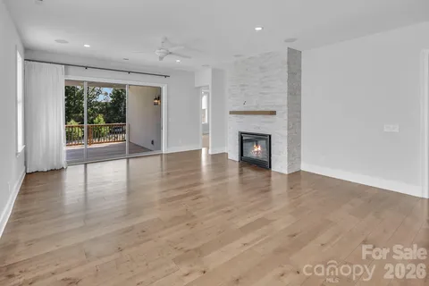 an empty room with wooden floor and a fireplace