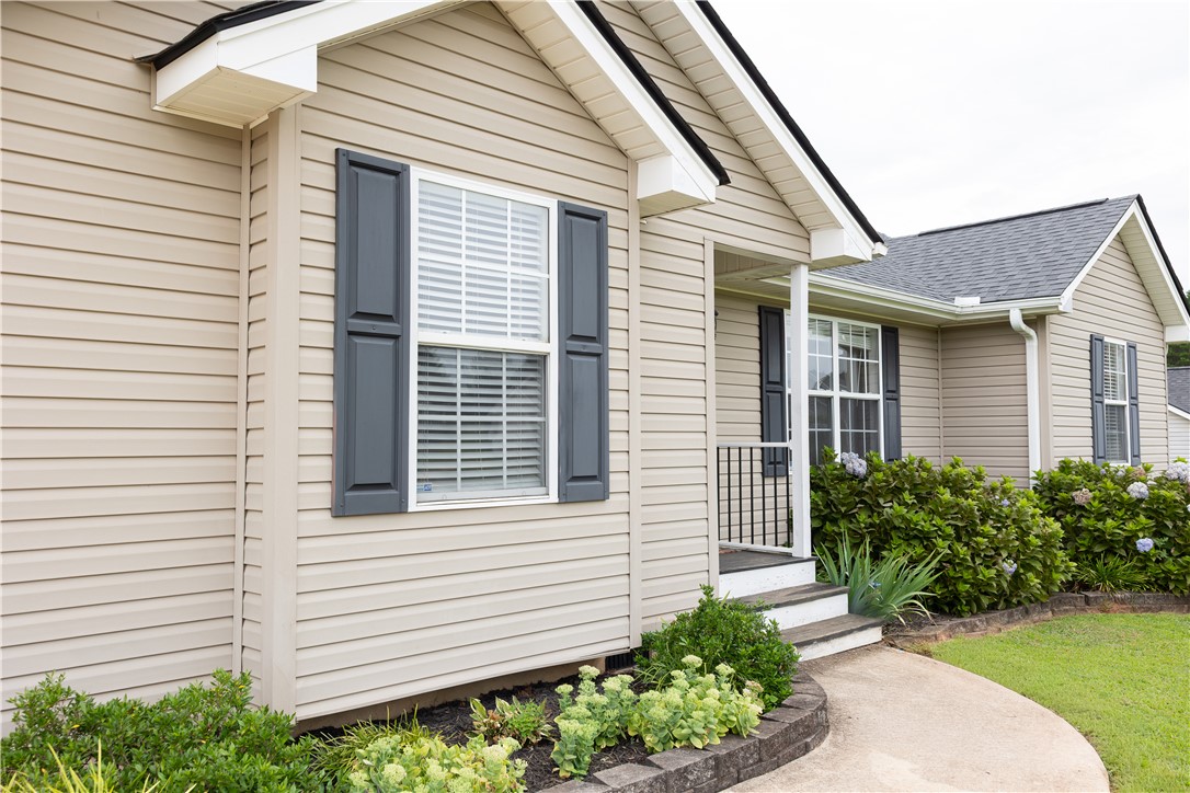 439 Chetola Road Seneca, SC 29672 - Photo 6 of 28 Crisp vinyl siding and contrasting shutters create classic curb appeal along the curved front walkway.