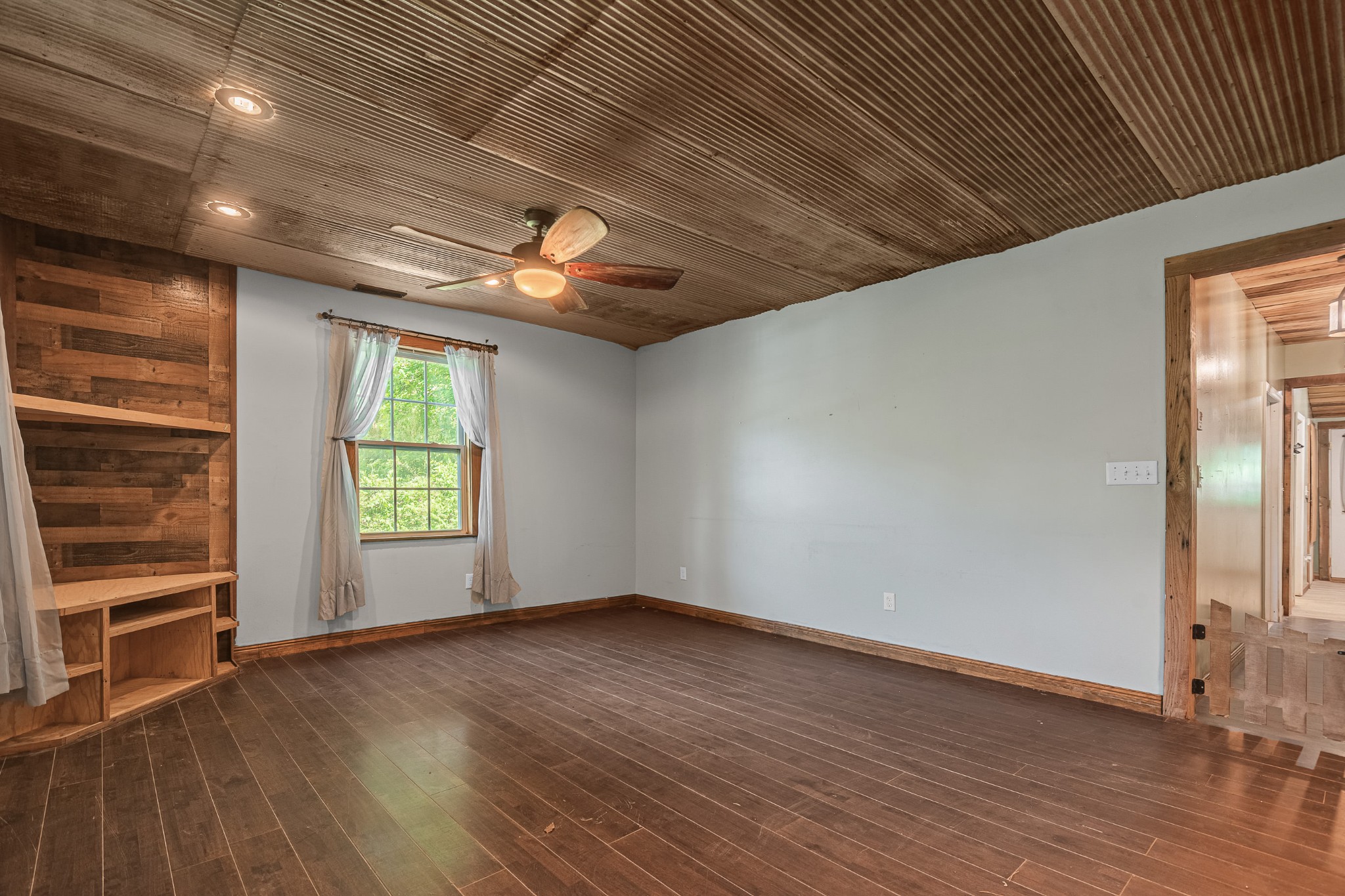 3671 Raleigh Beard Road Santa Fe, TN 38482 - Photo 7 of 32 an empty room with wooden floor a ceiling fan and windows