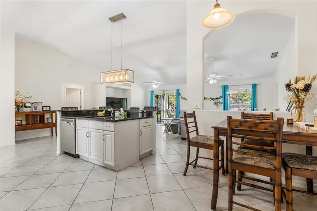 a kitchen with a dining table chairs and white cabinets