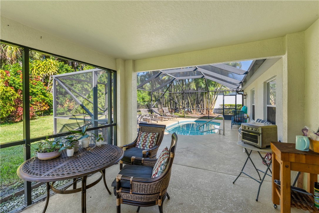 3660 2nd Street Southwest Vero Beach, FL 32968 - Photo 20 of 36 a dining room with furniture a flat screen tv and a floor to ceiling window