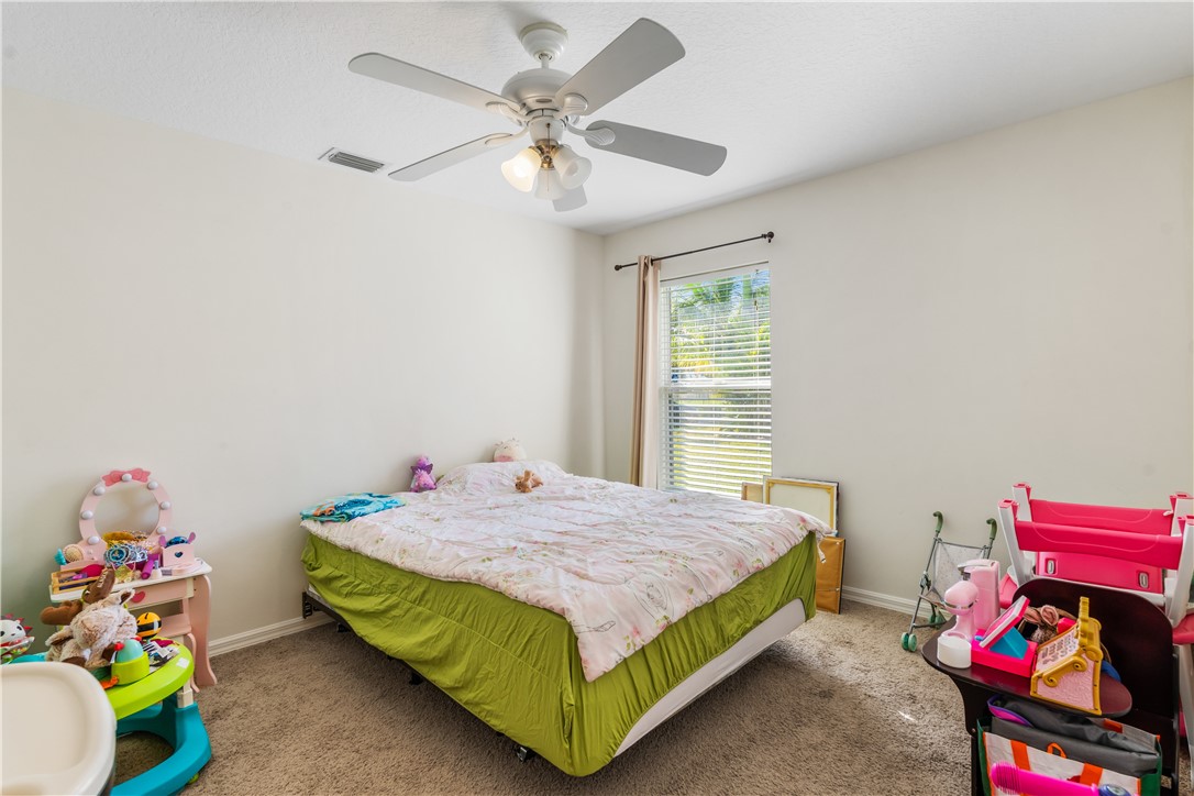 3660 2nd Street Southwest Vero Beach, FL 32968 - Photo 27 of 36 a bedroom with a bed and a chandelier
