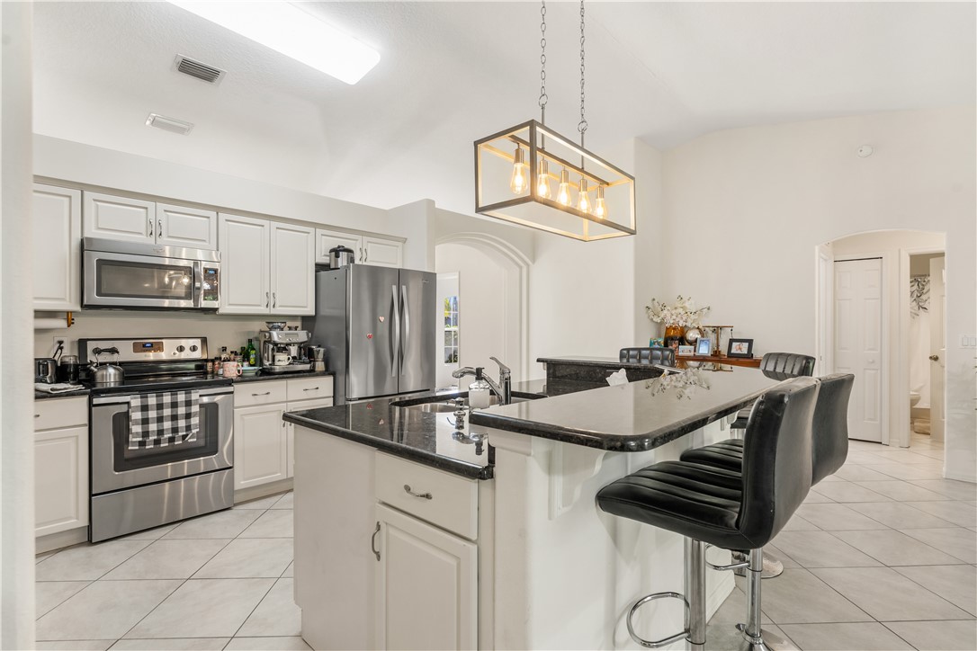 3660 2nd Street Southwest Vero Beach, FL 32968 - Photo 3 of 36 a kitchen with stainless steel appliances a sink a stove a microwave and cabinets