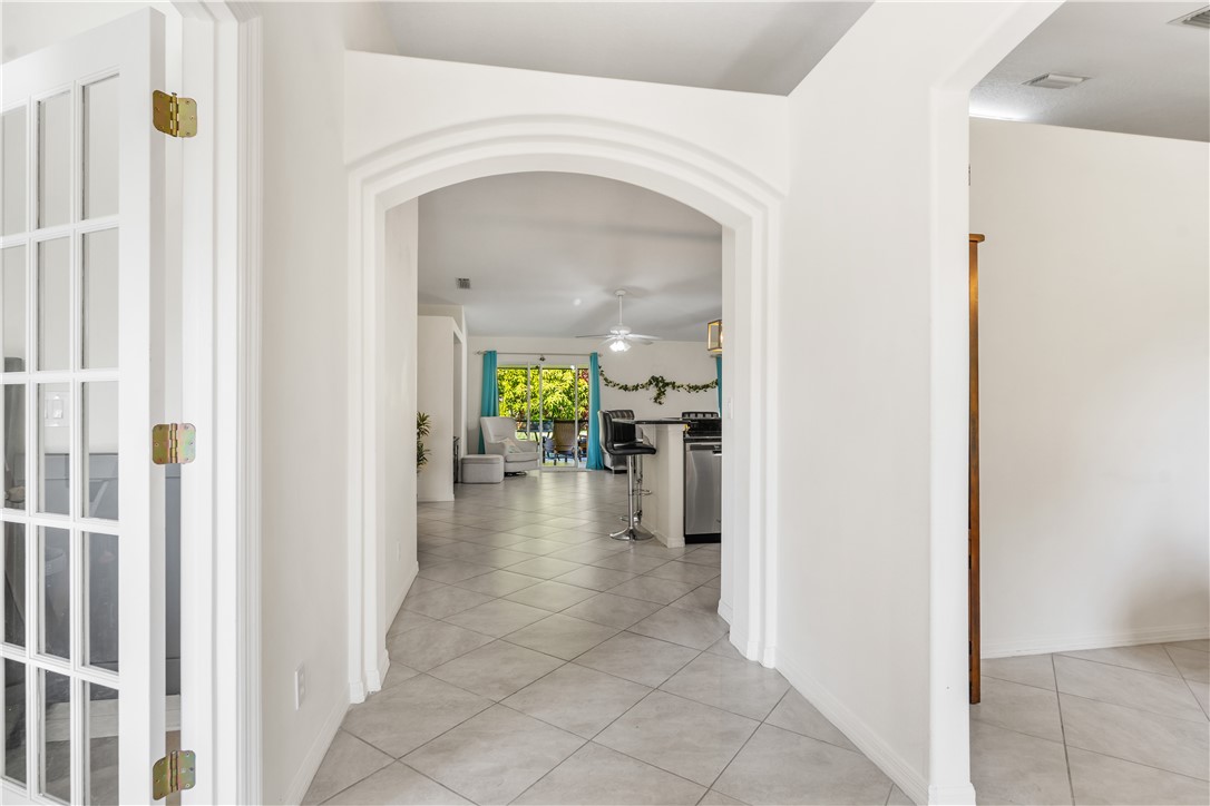 3660 2nd Street Southwest Vero Beach, FL 32968 - Photo 9 of 36 a view of a hallway with dining area a chandelier and a livingroom