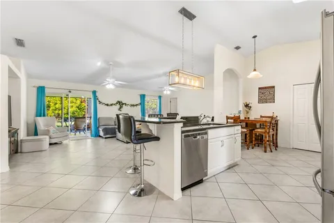 a kitchen with stainless steel appliances kitchen island granite countertop a stove a sink a dining table and chairs