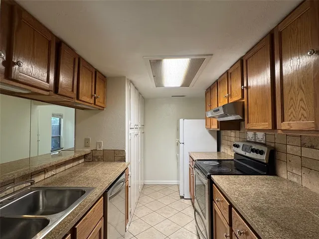 a kitchen with granite countertop stainless steel appliances and wooden cabinets