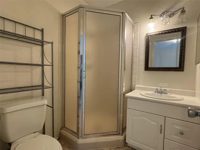 a bathroom with a toilet sink vanity tub and shower