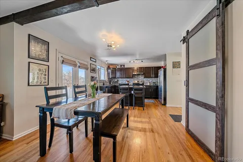 a view of a dining room with furniture a rug and wooden floor