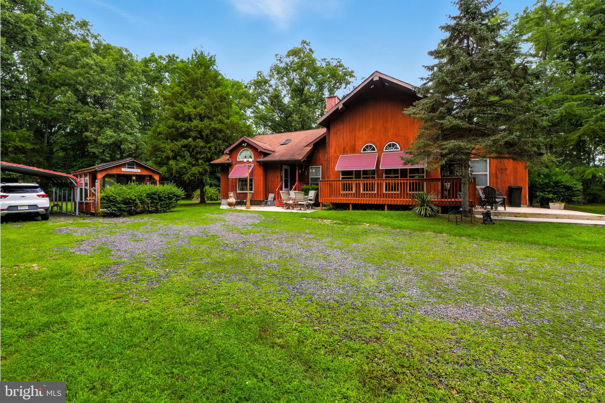 a view of a house with a big yard and large trees