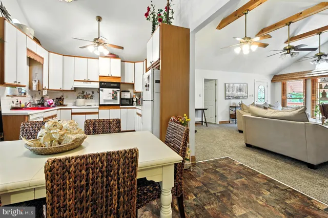 a view of a dining room and livingroom with furniture wooden floor a chandelier