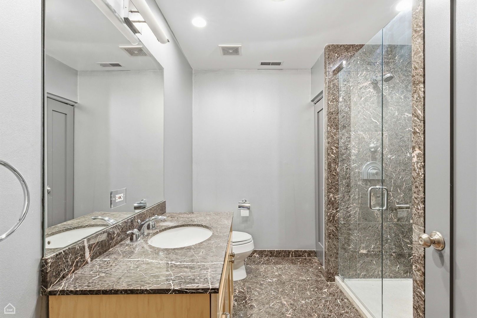 120 West Oak Street, Unit 4D Chicago, IL 60610 - Photo 12 of 18 a bathroom with a granite countertop sink a mirror and shower
