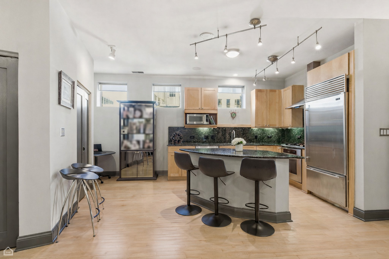 120 West Oak Street, Unit 4D Chicago, IL 60610 - Photo 3 of 18 a view of a kitchen with kitchen island stainless steel appliances refrigerator dining table and chairs