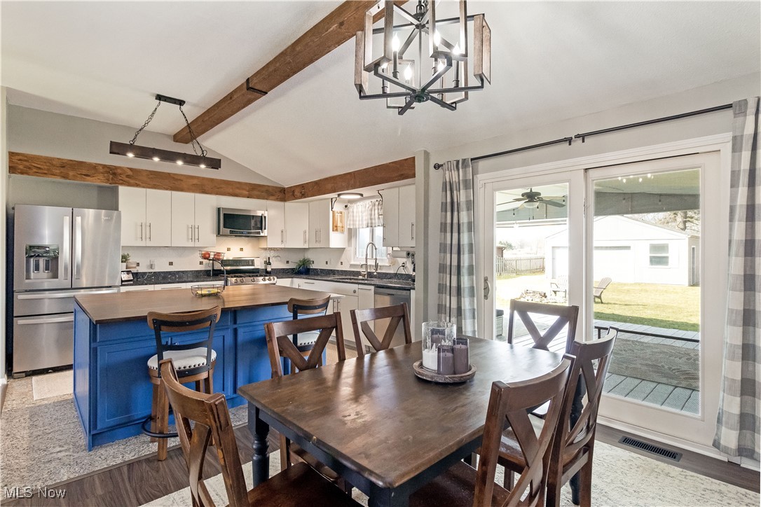 5900 Lear Nagle Road North Ridgeville, OH 44039 - Photo 5 of 35 Dining area featuring vaulted ceiling with beams, visible vents, a chandelier, and light wood-type flooring