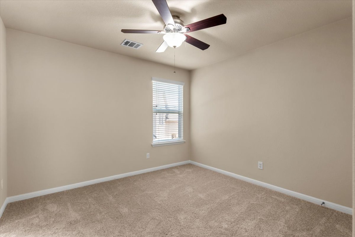 3451 Mayfield Ranch Boulevard, Unit 311 Round Rock, TX 78681 - Photo 29 of 40 Neutral-toned interior room featuring light beige walls and complementing carpet flooring