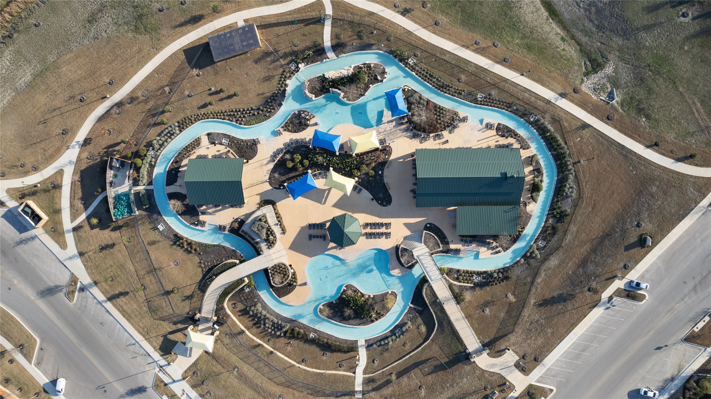 130 Wild Pecan Loop Buda, TX 78610 - Photo 29 of 31 Aerial view of a community amenity featuring a meandering water park, multiple shade structures, and surrounding pathways