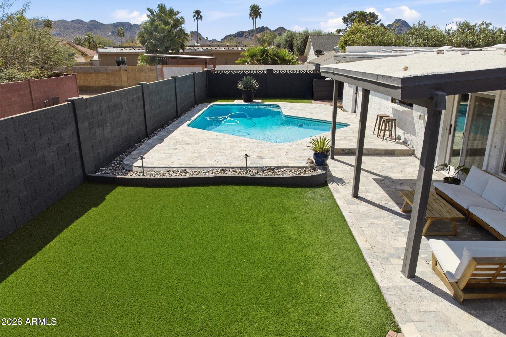 10245 North 34th Place Phoenix, AZ 85028 - Photo 21 of 26 a view of a swimming pool with a deck and a yard
