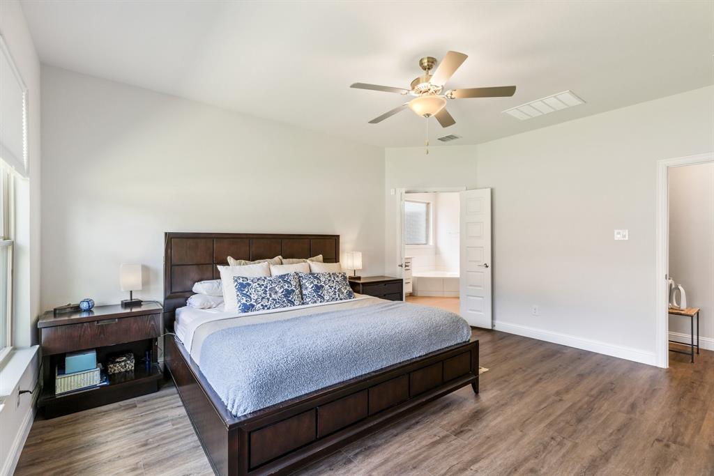 313 Savannah Lane Oak Point, TX 75068 - Photo 13 of 39 Bedroom with connected bathroom, wood finished floors, and ceiling fan