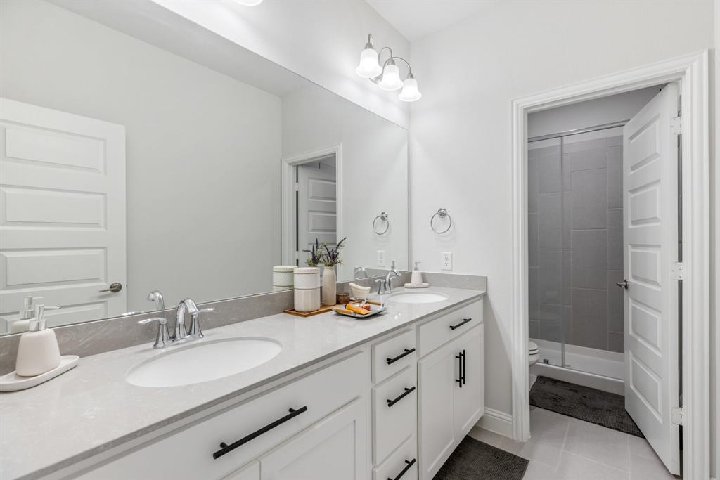 313 Savannah Lane Oak Point, TX 75068 - Photo 14 of 39 Bathroom with double vanity, a shower stall, and light tile patterned floors