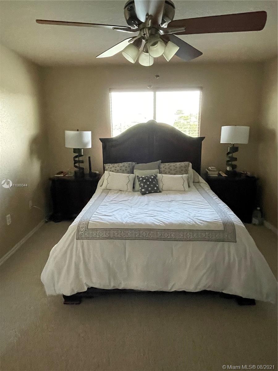 5924 Abbey Road Tamarac, FL 33321 - Photo 26 of 44 a bedroom with a bed and a chandelier