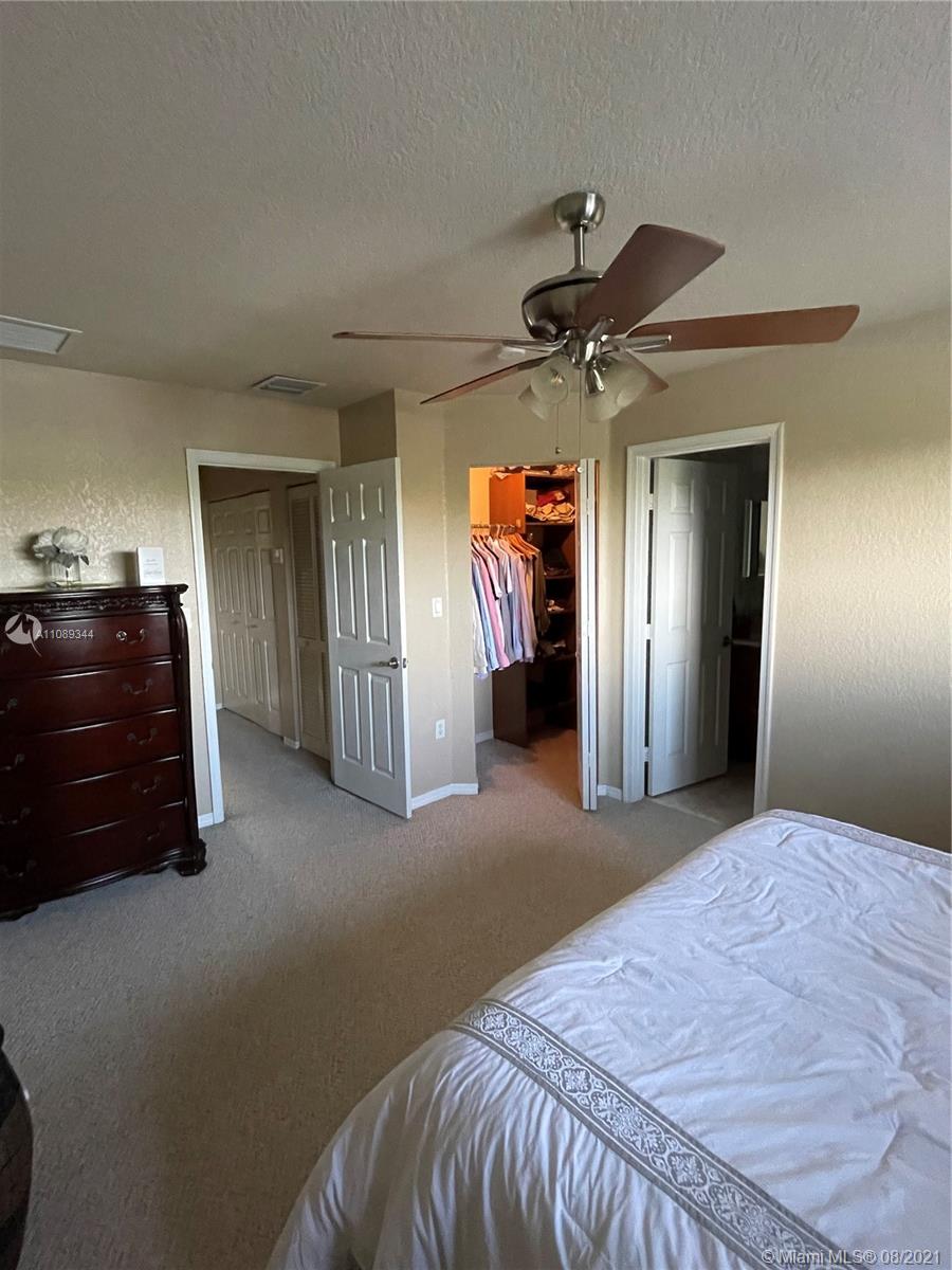 5924 Abbey Road Tamarac, FL 33321 - Photo 27 of 44 a bedroom with a bed and a chandelier
