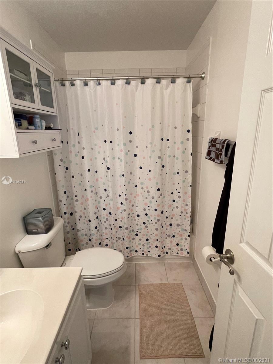 5924 Abbey Road Tamarac, FL 33321 - Photo 33 of 44 a bathroom with a sink a toilet and shower curtain