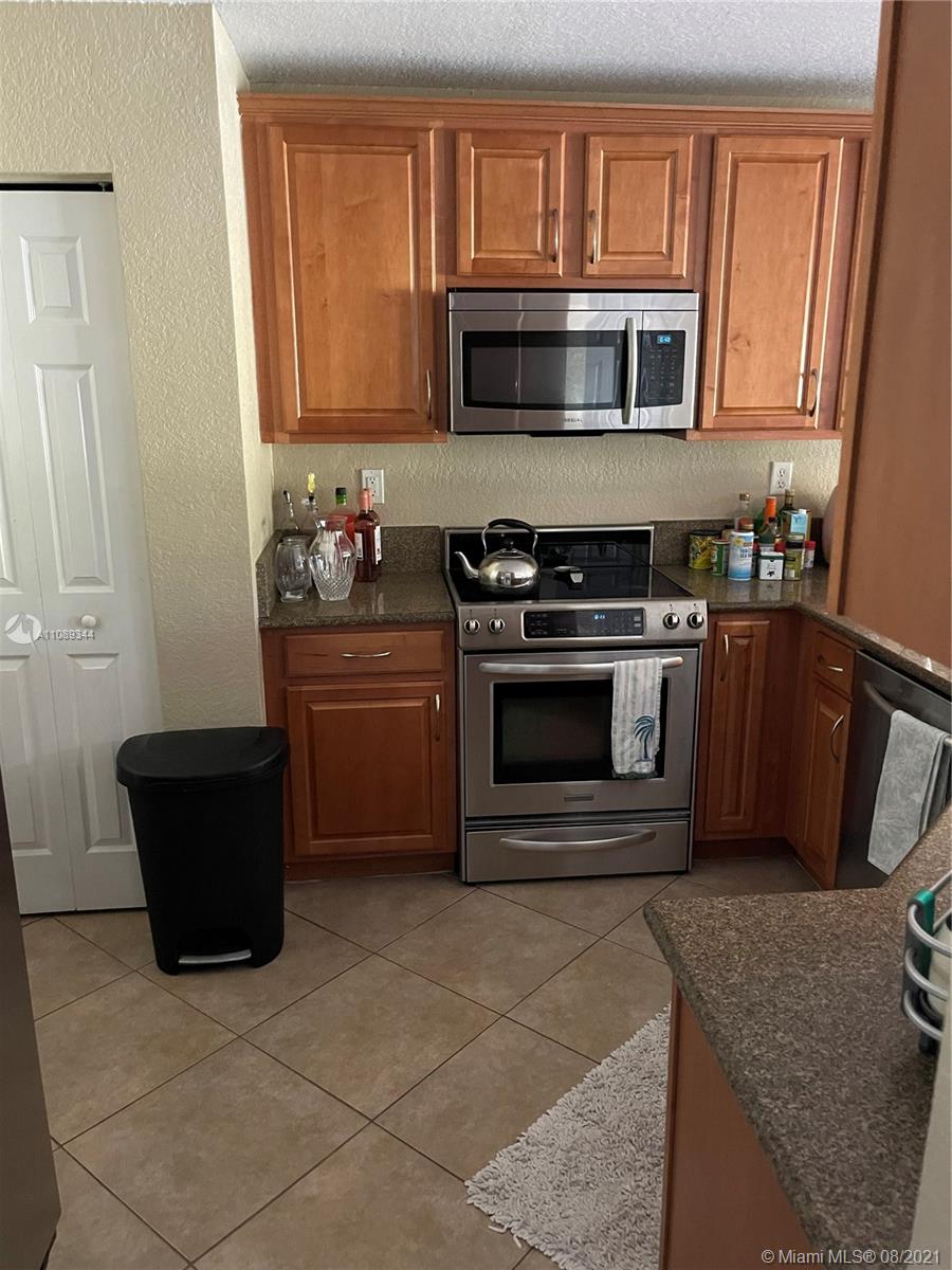 5924 Abbey Road Tamarac, FL 33321 - Photo 40 of 44 a kitchen with granite countertop a stove top oven microwave and cabinets