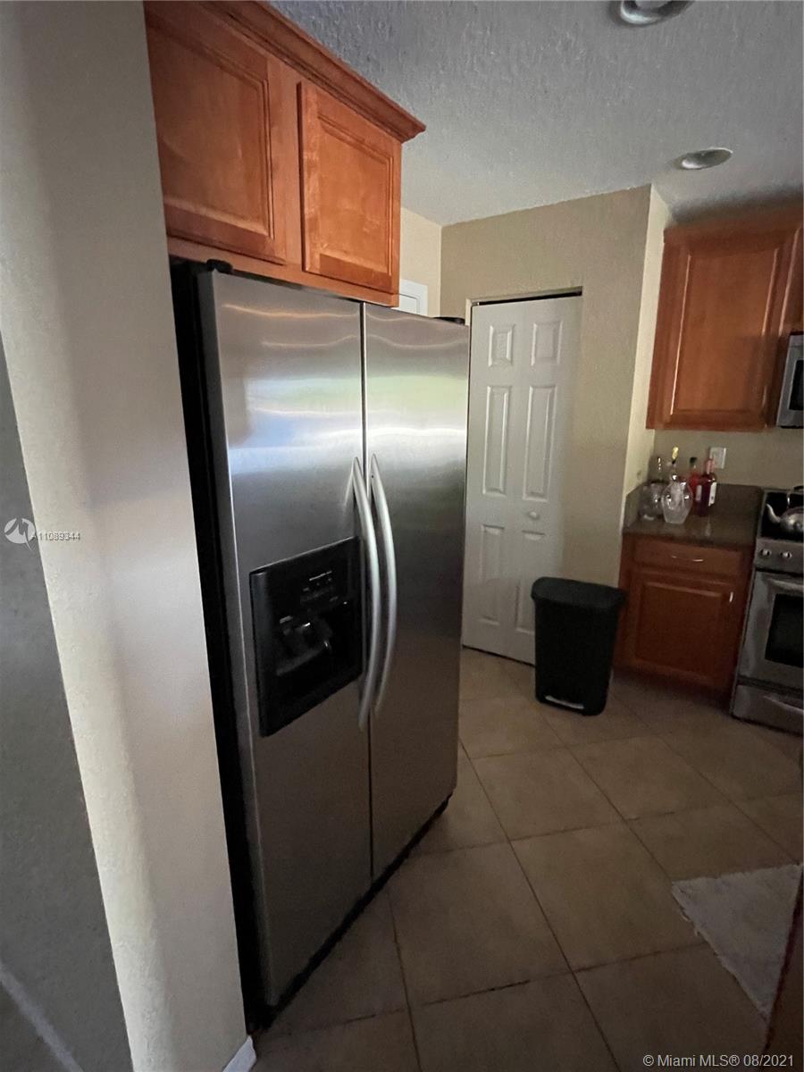 5924 Abbey Road Tamarac, FL 33321 - Photo 41 of 44 a kitchen with stainless steel appliances granite countertop a refrigerator a stove and a sink