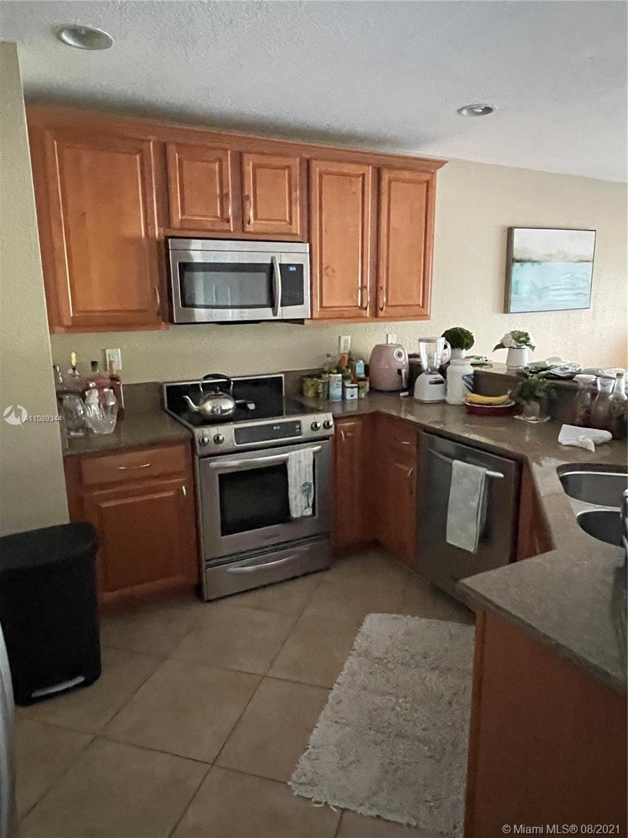 5924 Abbey Road Tamarac, FL 33321 - Photo 42 of 44 a kitchen with stainless steel appliances granite countertop a stove a sink dishwasher and a microwave oven with large cabinets