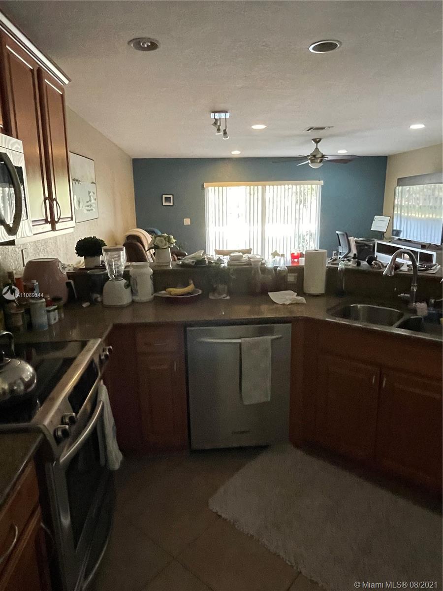 5924 Abbey Road Tamarac, FL 33321 - Photo 44 of 44 a kitchen with a sink stove and cabinets
