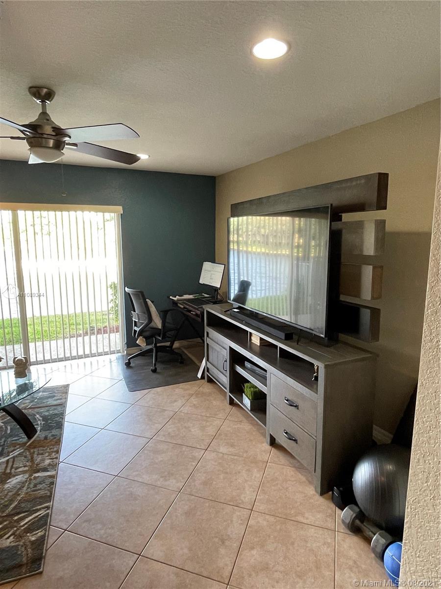 5924 Abbey Road Tamarac, FL 33321 - Photo 6 of 44 a living room with furniture a flat screen tv and floor to ceiling window