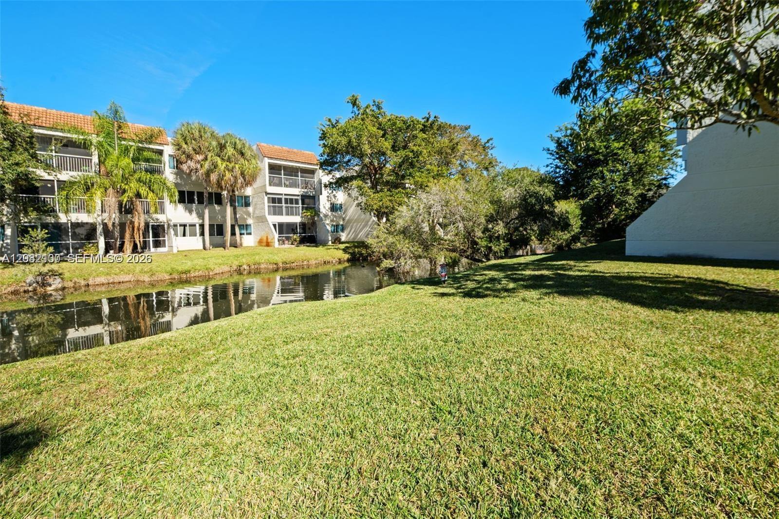301 Racquet Club Road, Unit 104 Weston, FL 33326 - Photo 18 of 21 a view of a building with a yard