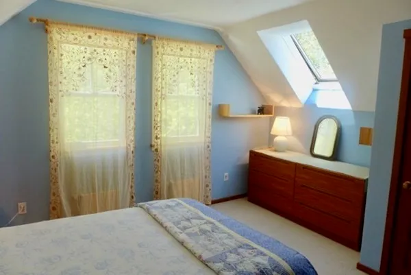 a bed sitting in a bedroom next to a window