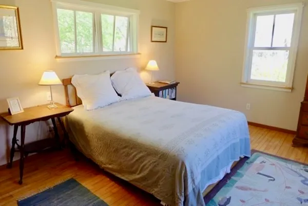a bedroom with a bed and a dresser next to a window