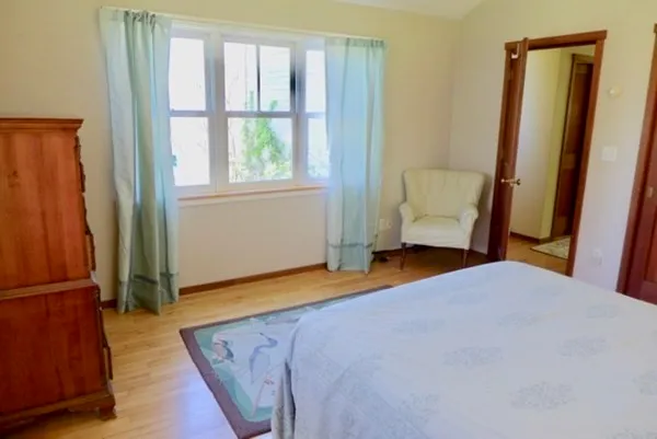 a bed sitting in a bedroom and chair