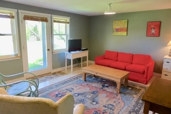 a living room with furniture a flat screen tv and a window