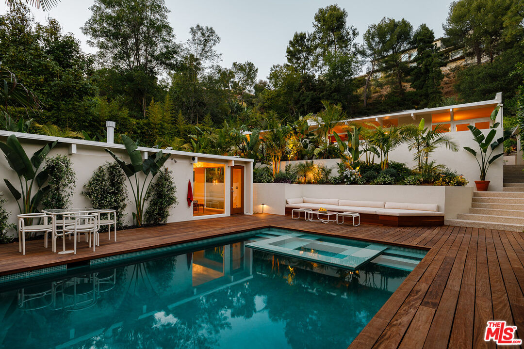 2544 Greenvalley Road Los Angeles, CA 90046 - Photo 2 of 56 a view of a roof deck with table and chairs with wooden floor and fence