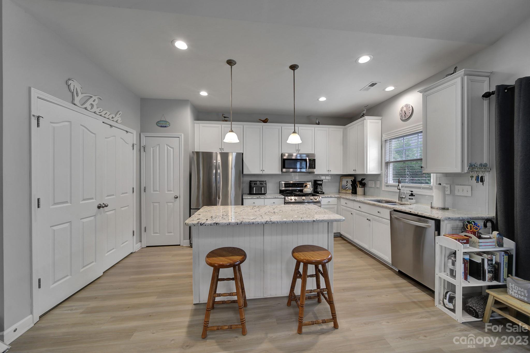 1079 Market Street Fort Mill, SC 29708 - Photo 14 of 46 a large kitchen with cabinets chairs and wooden floor
