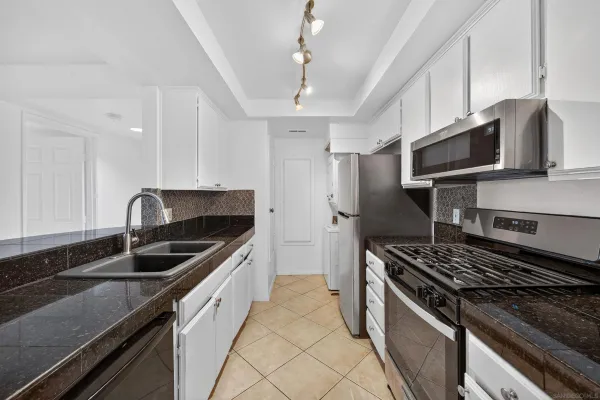a kitchen with granite countertop a sink stainless steel appliances and cabinets